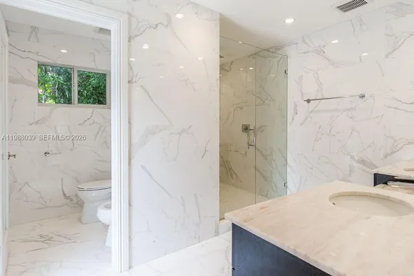 a bathroom with a double vanity sink a large mirror and shower