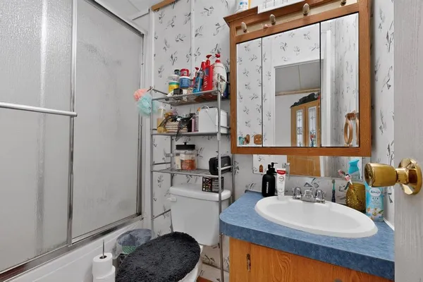 a bathroom with a sink a toilet and a mirror