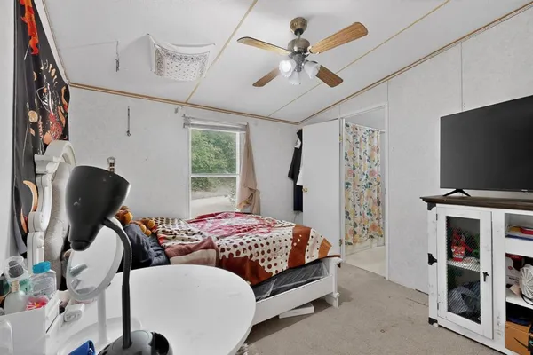 a bedroom with furniture and a flat screen tv