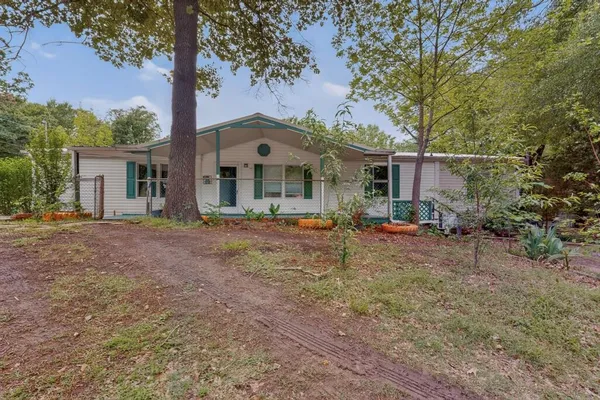 a front view of house with yard and trees around