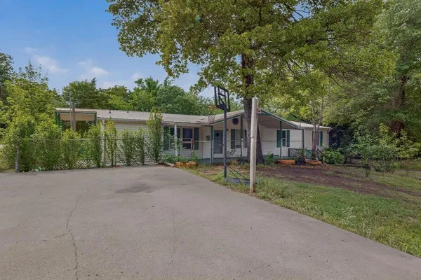 front view of a house with a yard and potted plants