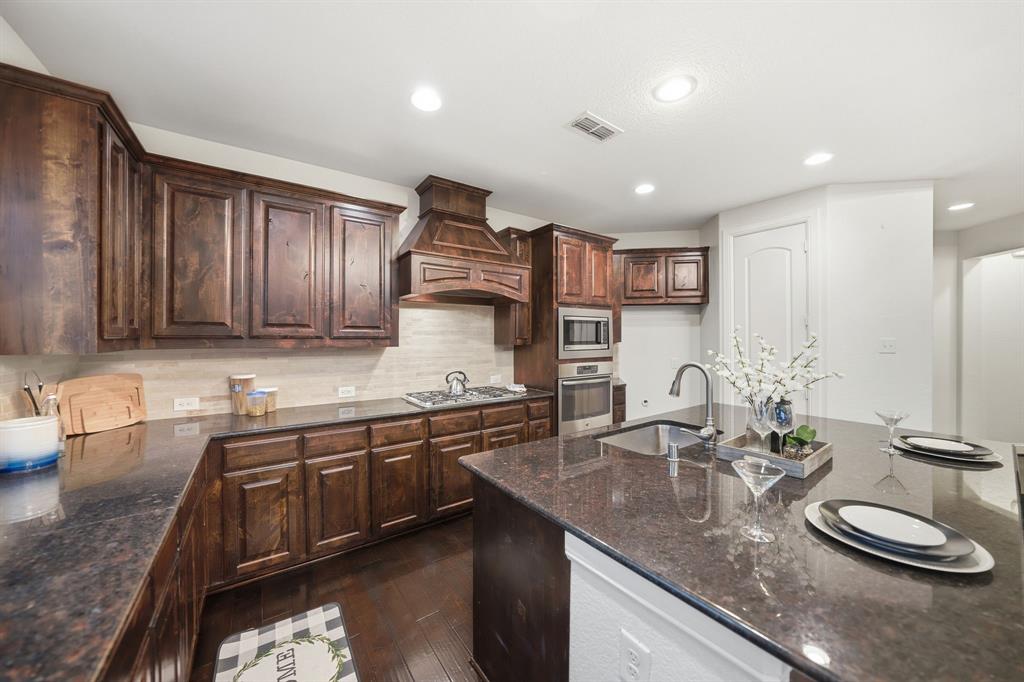 624 Sorrell Road McKinney, TX 75072 - Photo 10 of 28 a kitchen with stainless steel appliances granite countertop a sink a stove and a wooden cabinets