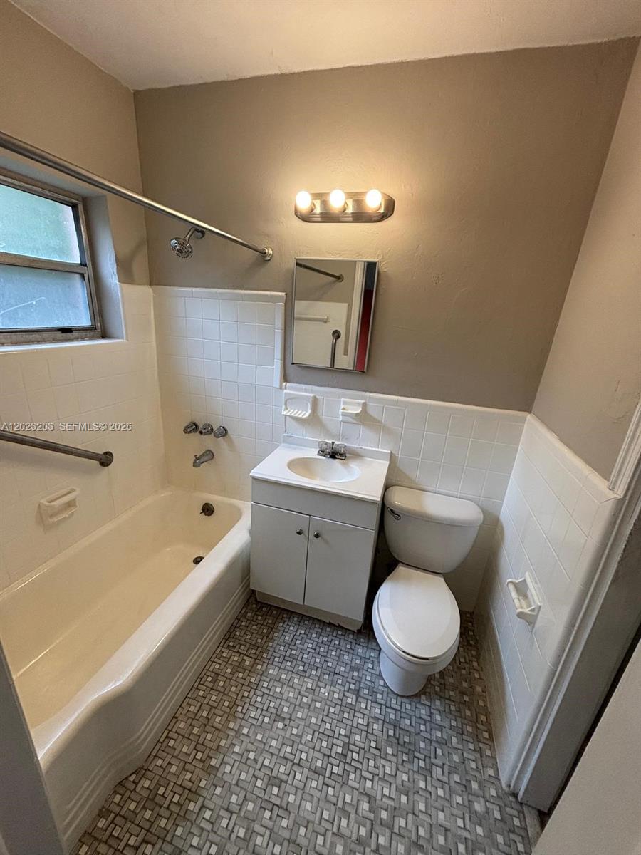 520 Southwest 4th Street, Unit 11 Miami, FL 33130 - Photo 4 of 7 a bathroom with a granite countertop toilet a sink and a bathtub