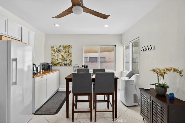 a kitchen with stainless steel appliances a table chairs and a refrigerator