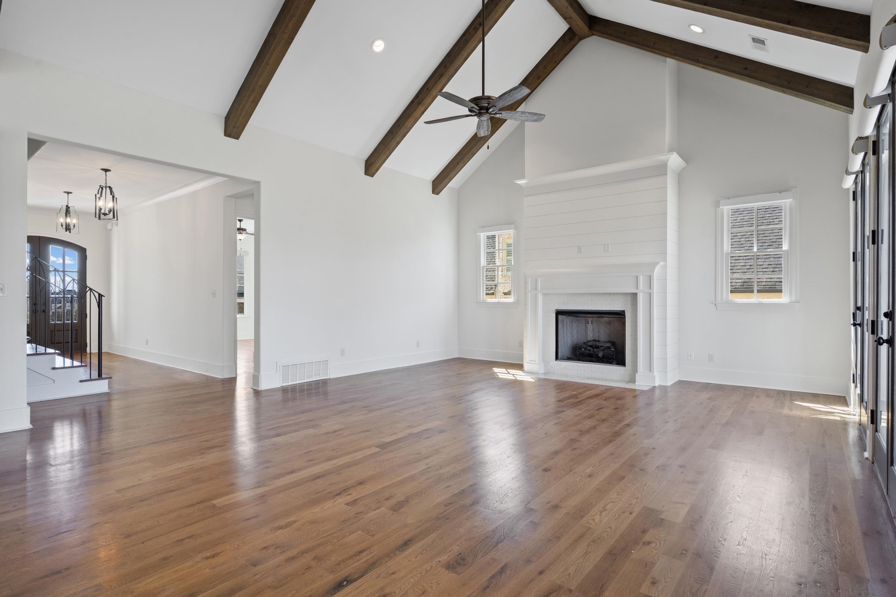 12608 Bravo Road Collierville, TN 38017 - Photo 15 of 40 an empty room with wooden floor fireplace and windows