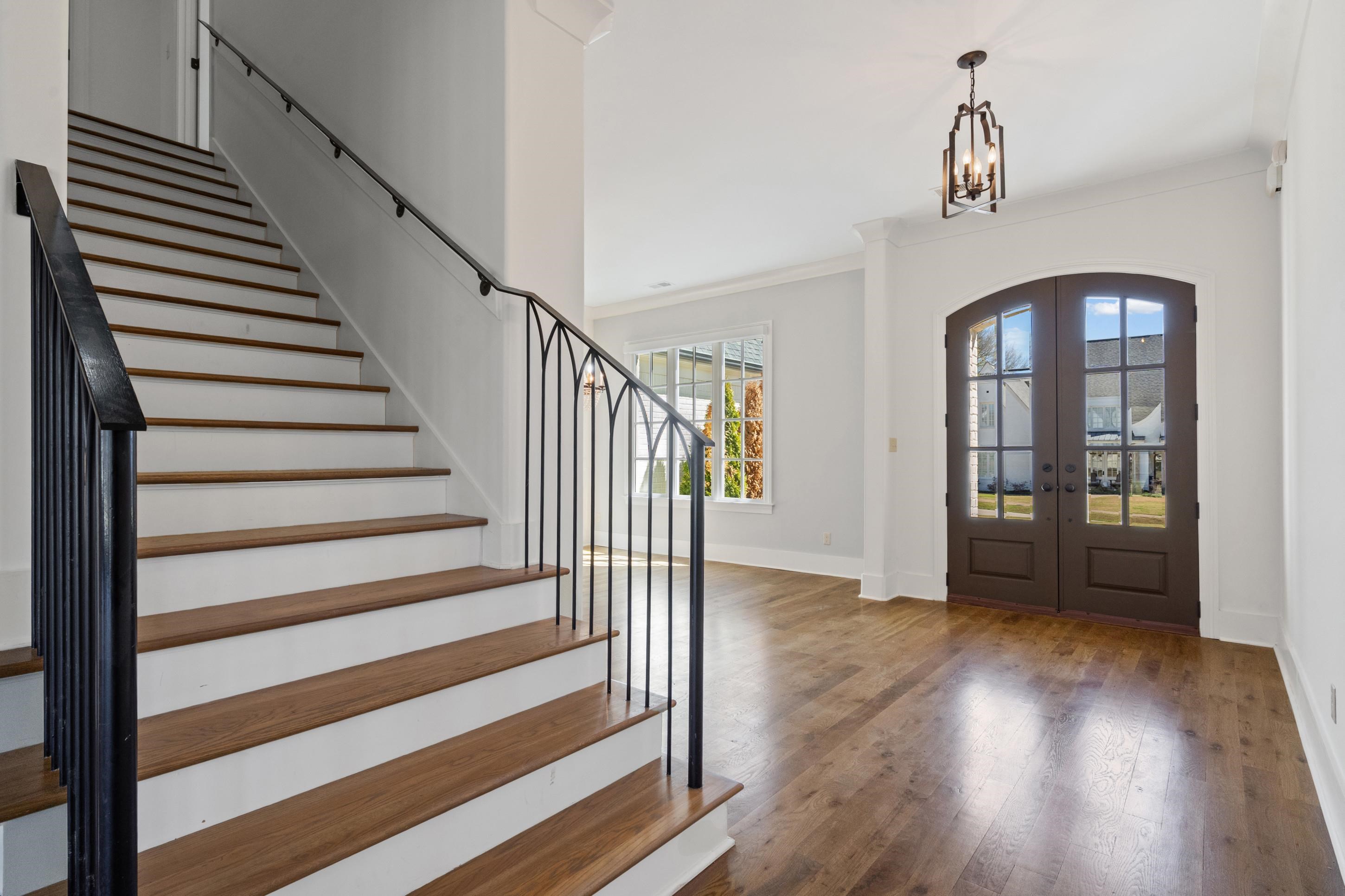 12608 Bravo Road Collierville, TN 38017 - Photo 20 of 40 Entrance foyer with french doors, dark wood-type flooring, crown molding, and hanging lights