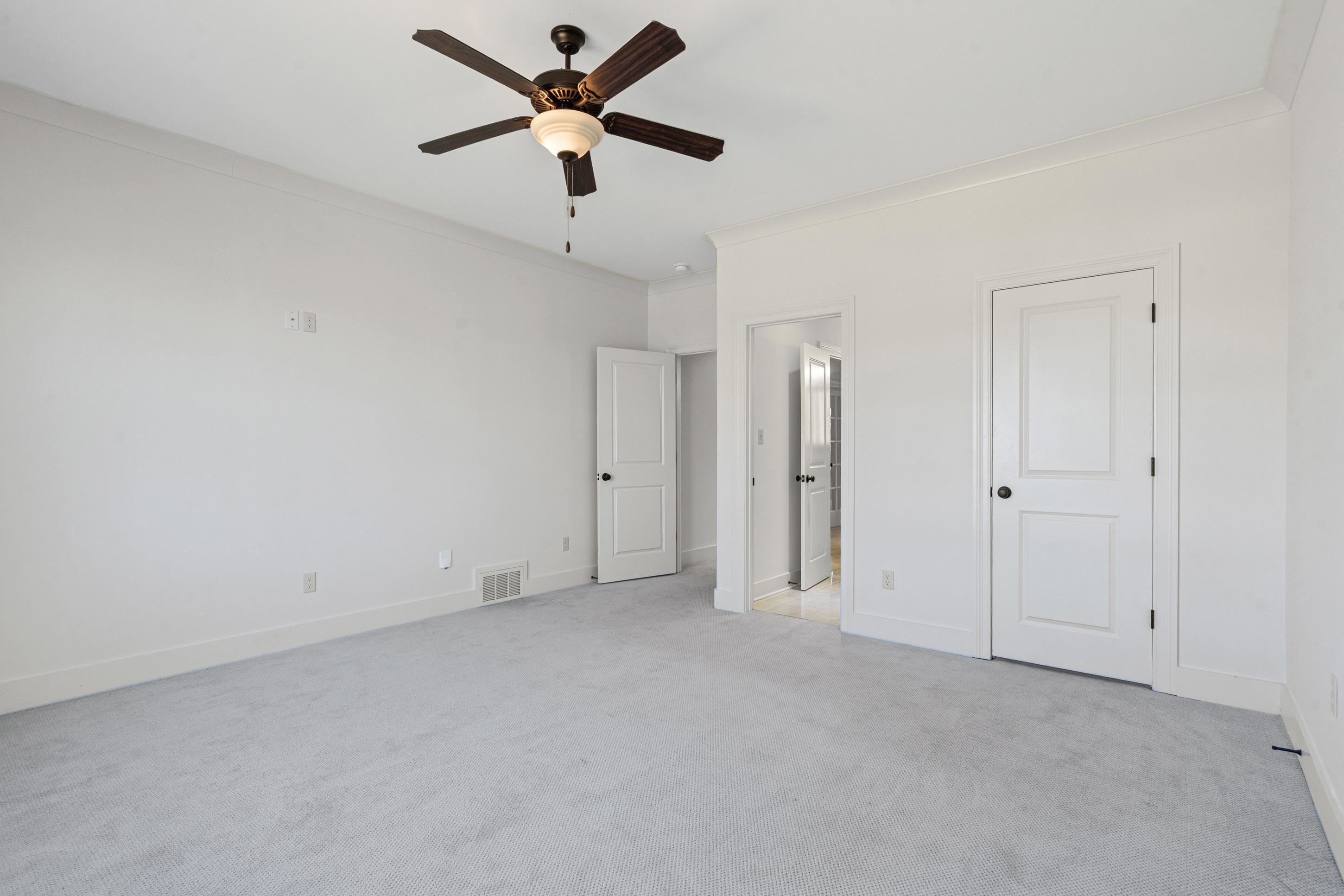 12608 Bravo Road Collierville, TN 38017 - Photo 33 of 40 Unfurnished bedroom with light carpet, ornamental molding, ensuite bathroom, and ceiling fan