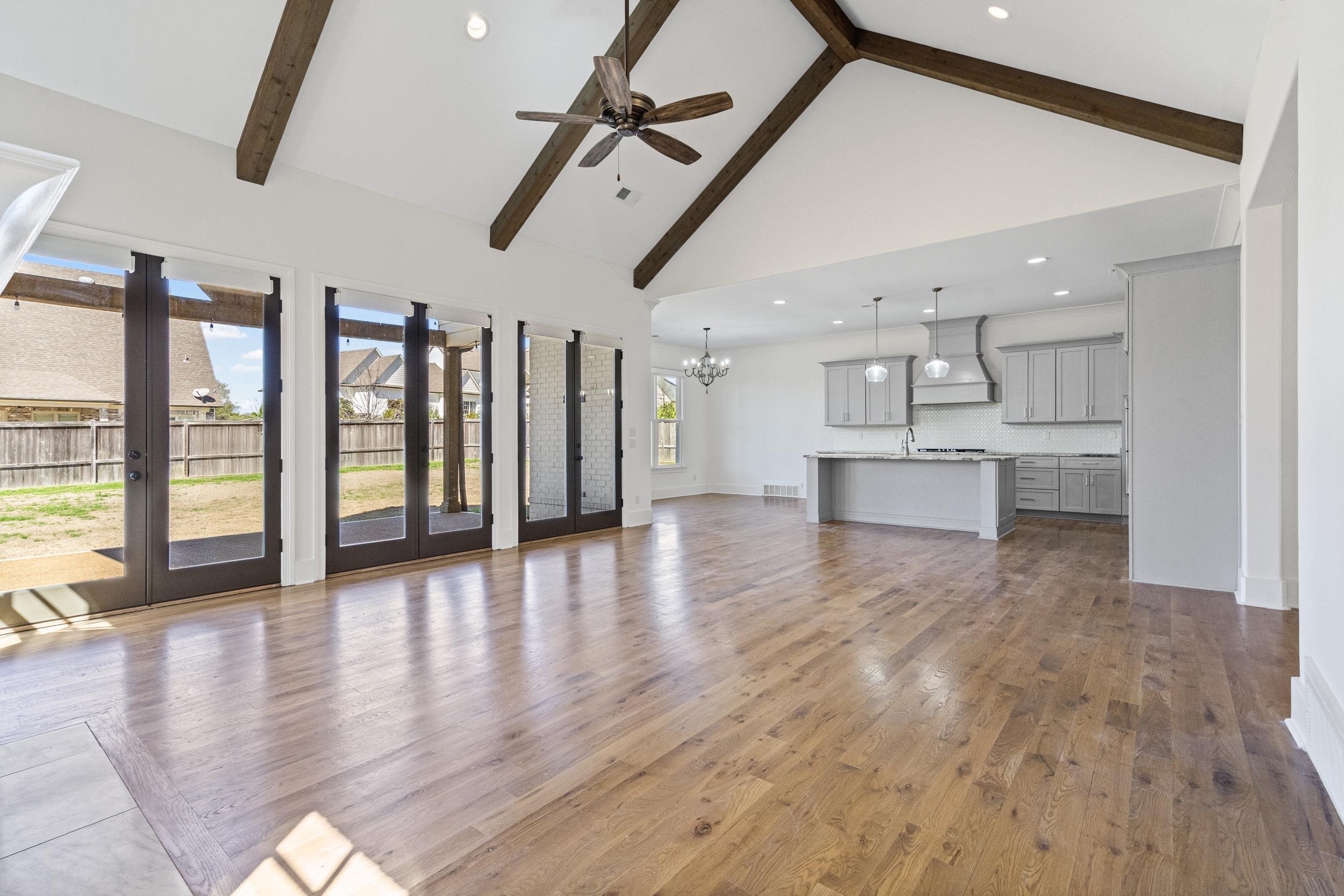 12608 Bravo Road Collierville, TN 38017 - Photo 8 of 40 Unfurnished living room featuring a chandelier, light wood-type flooring, and ceiling fan
