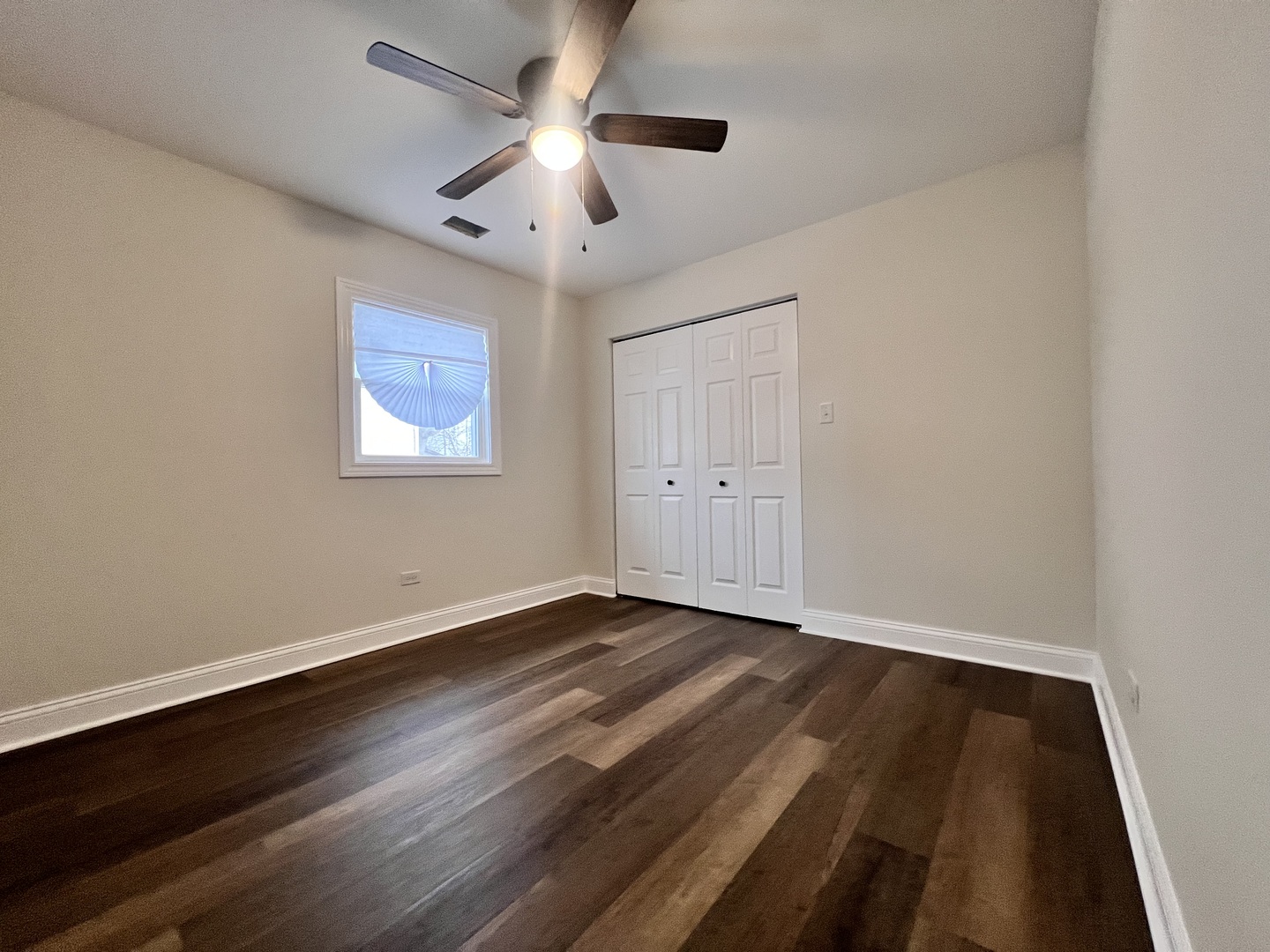 16607 Winchester Avenue Markham, IL 60428 - Photo 18 of 32 a view of an empty room with wooden floor and a ceiling fan