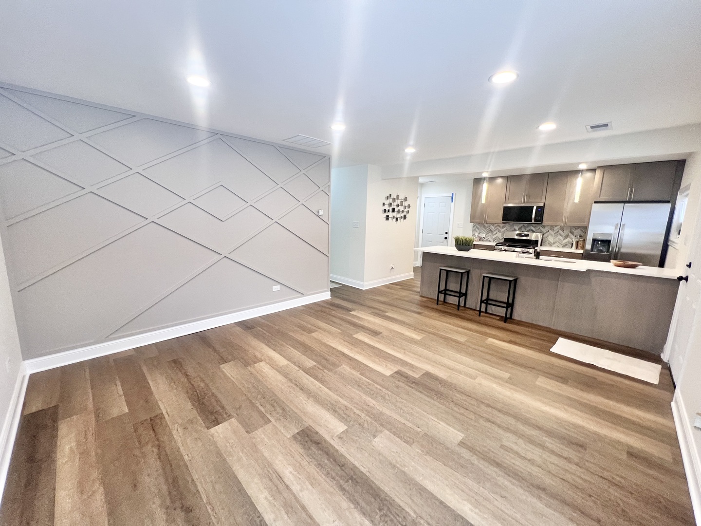16607 Winchester Avenue Markham, IL 60428 - Photo 4 of 32 a large white kitchen with wooden floor and stainless steel appliances