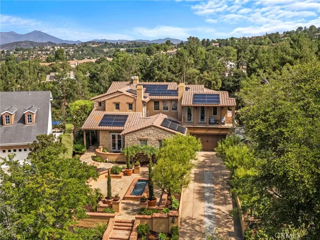 an aerial view of residential houses with outdoor space and trees