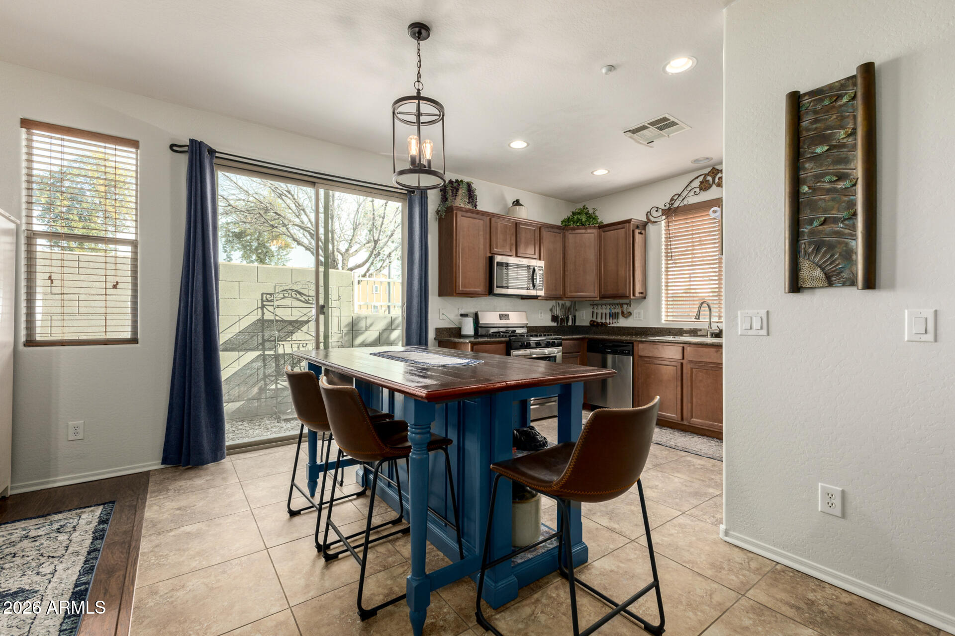 1849 South Balboa Drive Gilbert, AZ 85295 - Photo 6 of 35 a kitchen with stainless steel appliances granite countertop a stove a refrigerator a sink a dining table and chairs with wooden floor