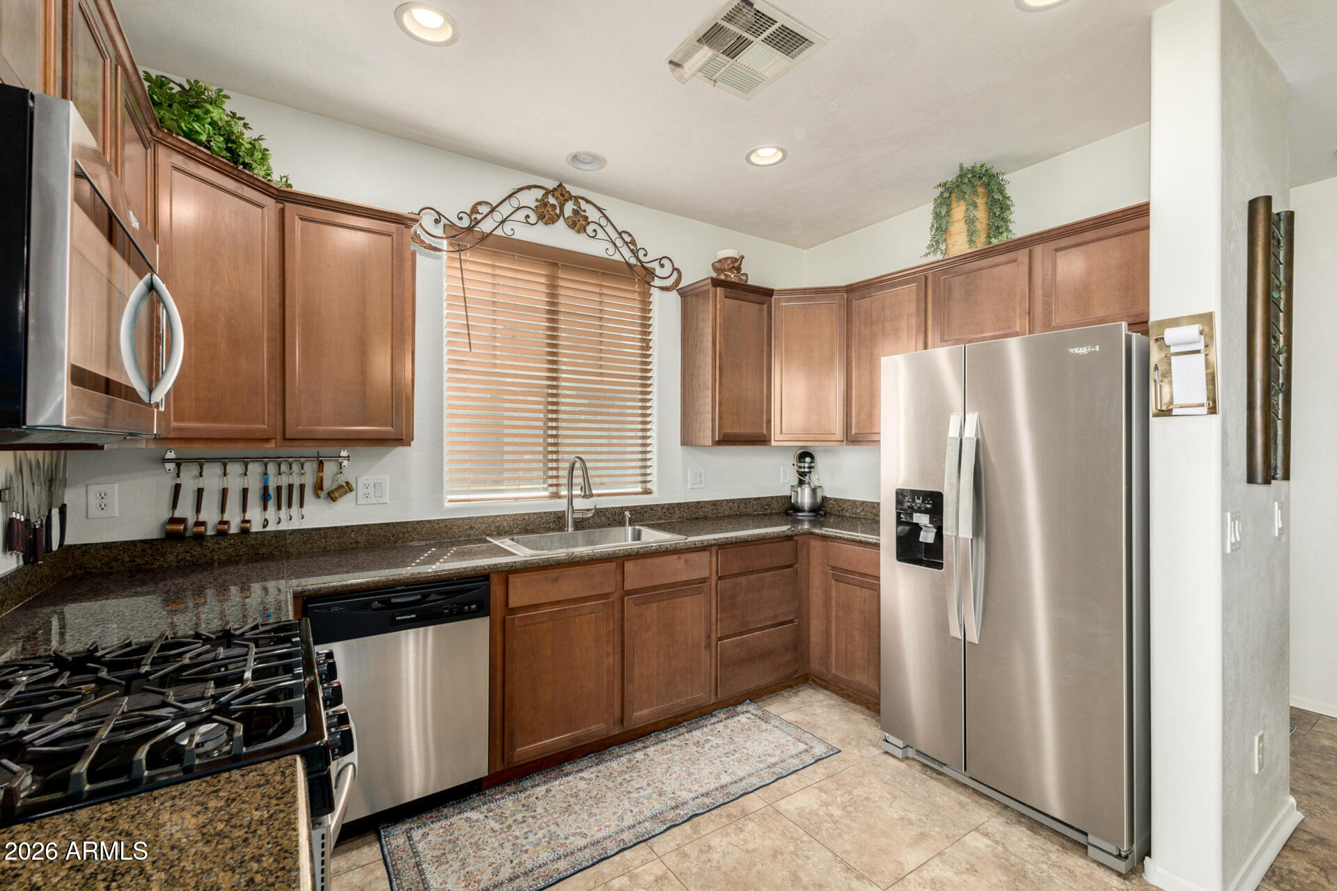 1849 South Balboa Drive Gilbert, AZ 85295 - Photo 9 of 35 a kitchen with stainless steel appliances granite countertop a refrigerator a sink dishwasher a stove and a microwave oven