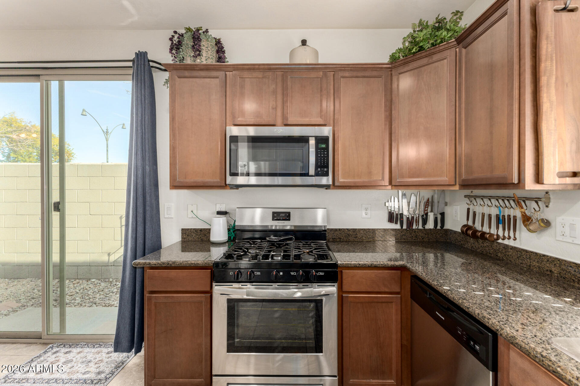 1849 South Balboa Drive Gilbert, AZ 85295 - Photo 10 of 35 a kitchen with granite countertop wooden cabinets and a stove top oven