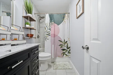 a bathroom with a granite countertop sink toilet and shower
