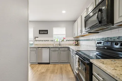 a kitchen with stainless steel appliances granite countertop a sink stove and cabinets