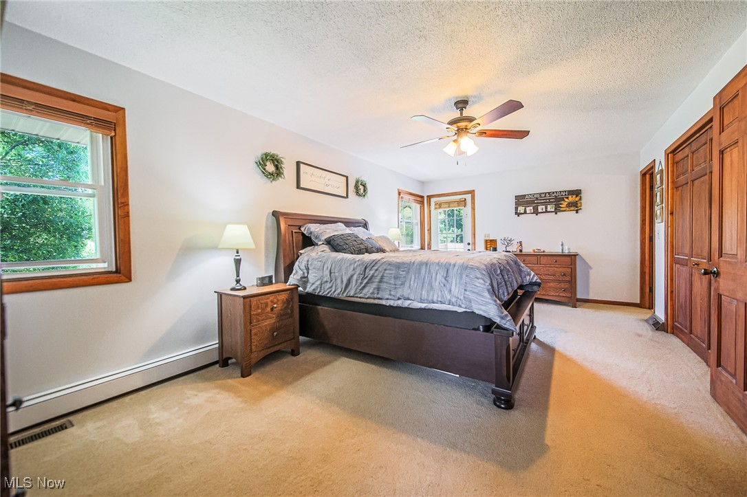 1791 Beal Road Mansfield, OH 44903 - Photo 23 of 50 Bedroom featuring light carpet, ceiling fan, a textured ceiling, and a baseboard heating unit