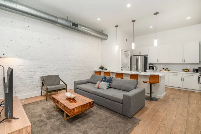 a living room with furniture and kitchen view