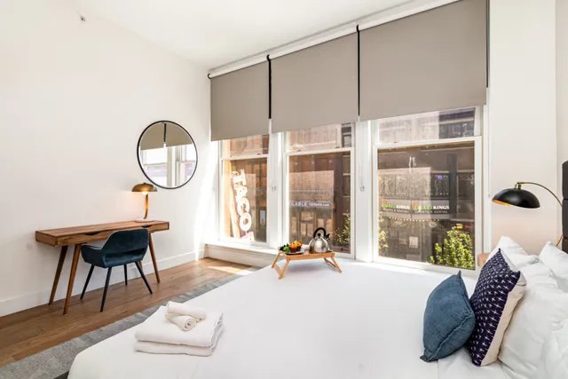 a bedroom with a bed and a large window