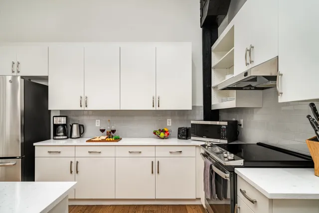 a kitchen with stainless steel appliances a stove a refrigerator a sink a stove and cabinets