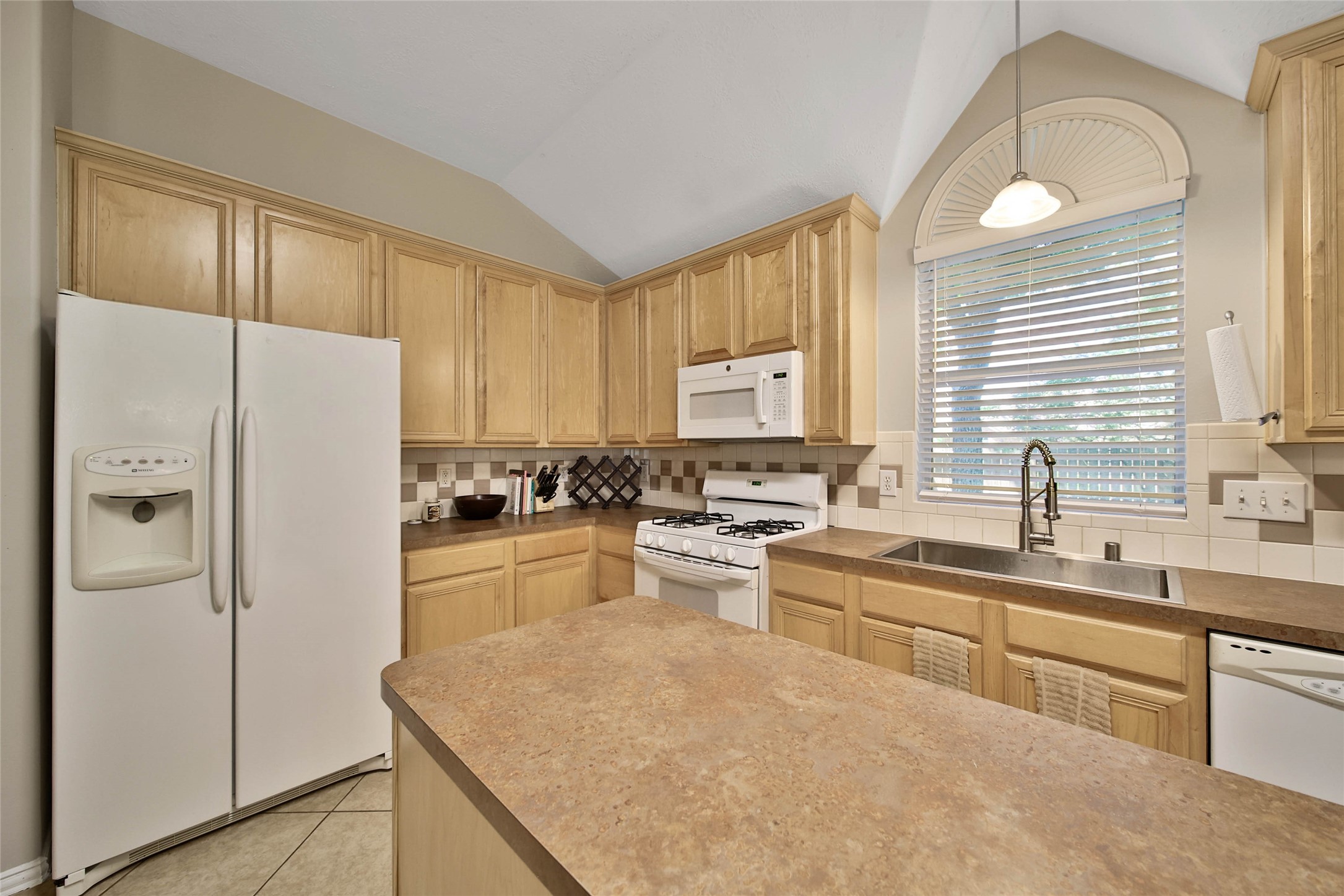 21338 Timber Pines Drive Spring, TX 77388 - Photo 16 of 29 a kitchen with a refrigerator a sink and cabinets