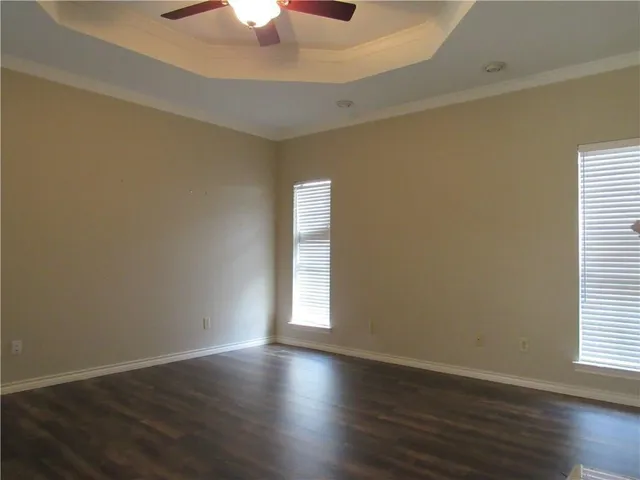 a view of an empty room with wooden floor fireplace and a window