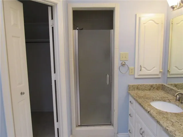 a bathroom with a granite countertop sink a toilet and a mirror