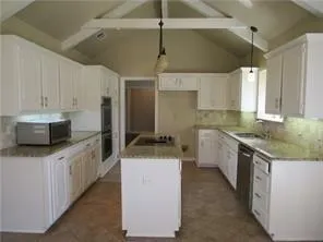 a kitchen with a stove sink and cabinets
