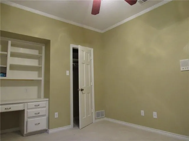 a view of an empty room with wooden floor fireplace and a window