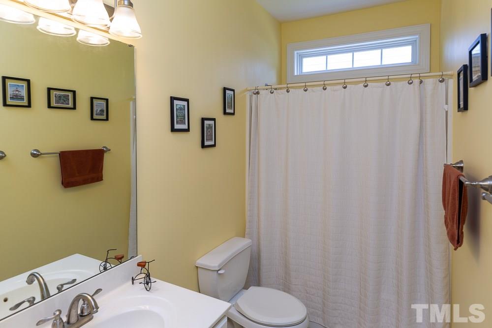 5116 Bartons Enclave Lane Raleigh, NC 27613 - Photo 12 of 30 a white toilet sitting next to a bathroom sink
