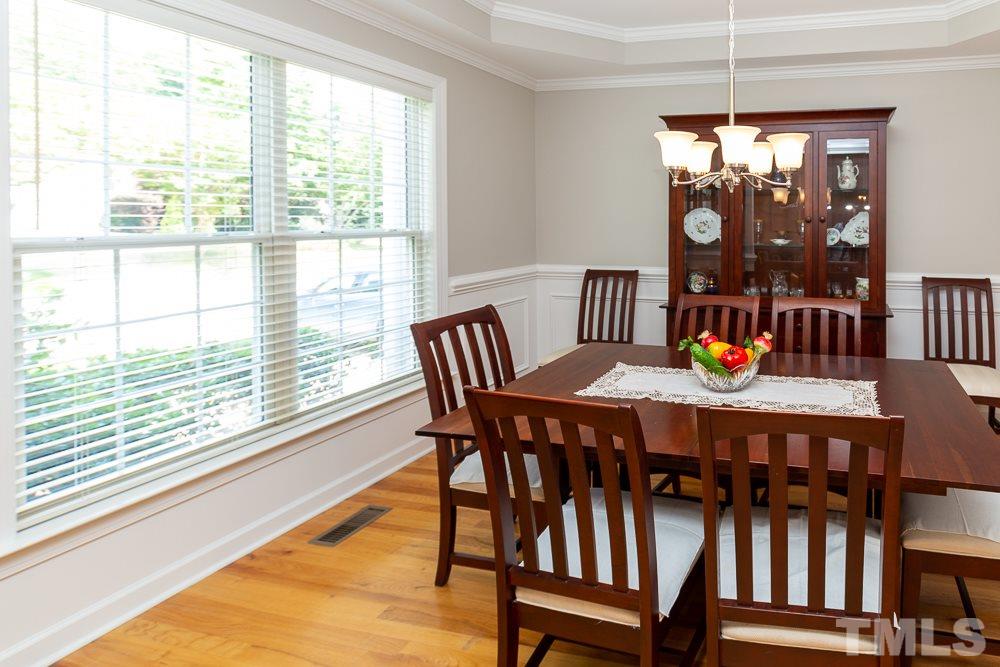 5116 Bartons Enclave Lane Raleigh, NC 27613 - Photo 4 of 30 a dining room with furniture a chandelier and wooden floor