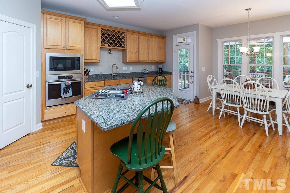 5116 Bartons Enclave Lane Raleigh, NC 27613 - Photo 5 of 30 a kitchen with granite countertop a table chairs stove and granite counter tops