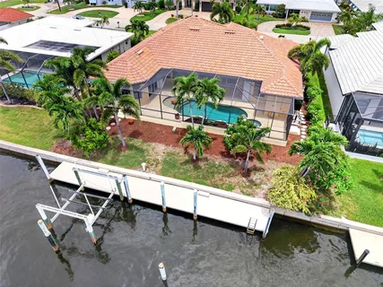 an aerial view of a house with a swimming pool and lake view