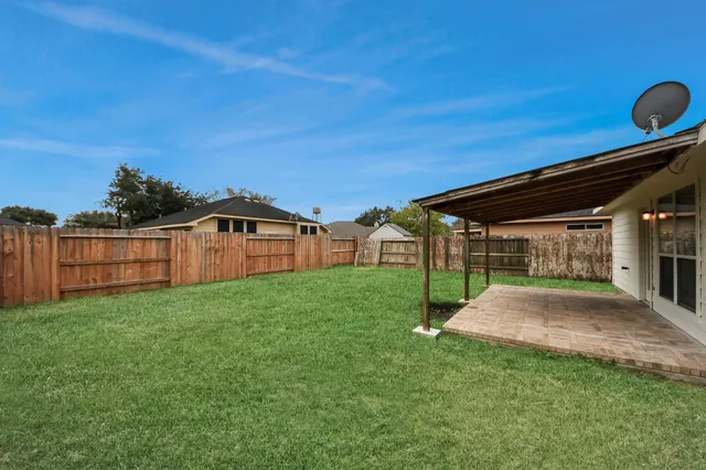a view of a backyard with wooden fence