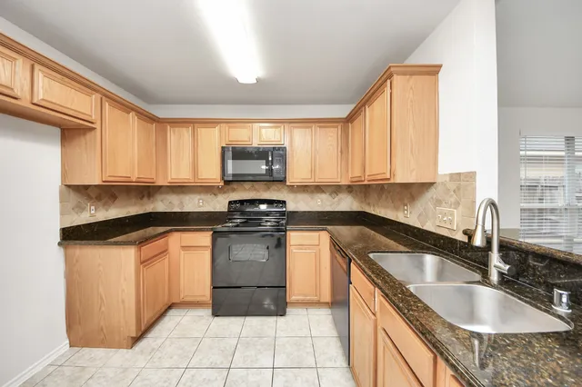 a kitchen with stainless steel appliances granite countertop a sink stove and microwave