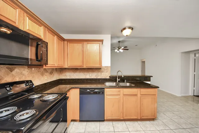 a kitchen with stainless steel appliances granite countertop a stove a sink and a microwave