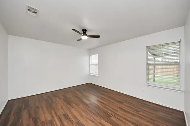 wooden floor in an empty room with a window