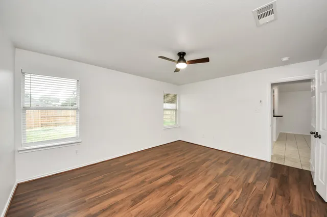 wooden floor in an empty room with a window