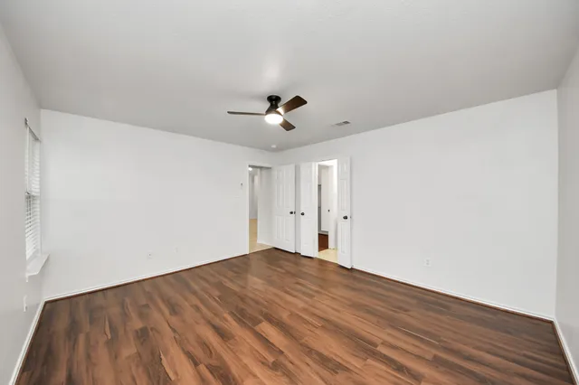 a view of an empty room with wooden floor