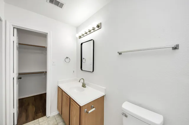 a bathroom with a sink a toilet and mirror