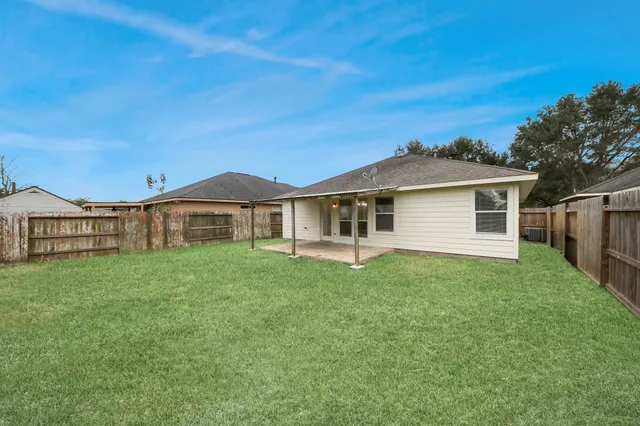 a view of a yard in front of a house with large trees
