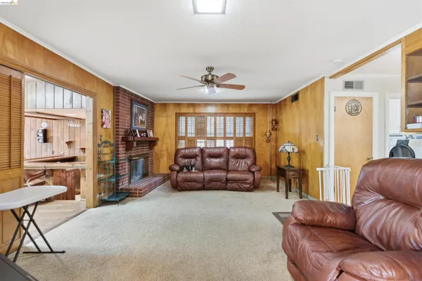 a living room with furniture ceiling fan and a window