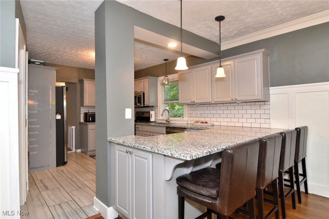 2652 Exeter Road Cleveland, OH 44118 - Photo 12 of 40 Eat-in Kitchen bar has under-counter storage and pendant lighting