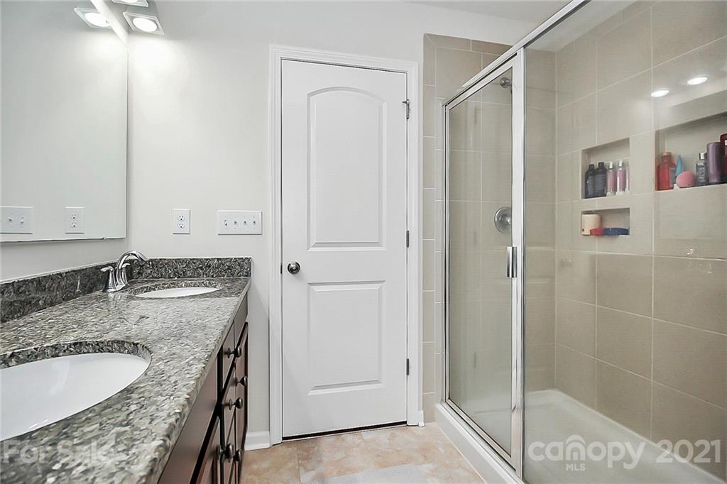 3034 Riker Street Clover, SC 29710 - Photo 27 of 42 a bathroom with a granite countertop sink a mirror and shower
