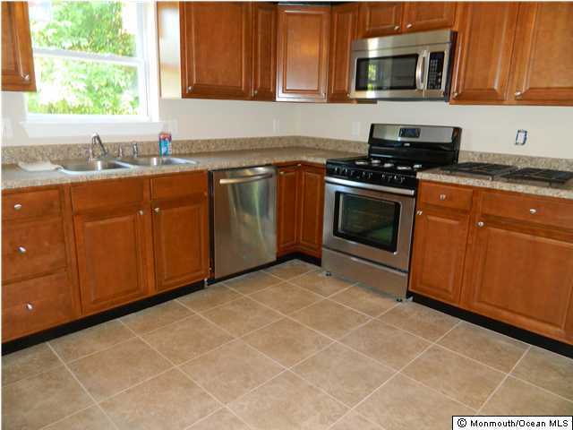 412 Georgia Tavern Road Howell, NJ 07731 - Photo 3 of 3 a kitchen with granite countertop a sink a stove top oven and cabinetry
