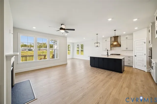 a large kitchen with stainless steel appliances kitchen island a large counter top and a wooden floors