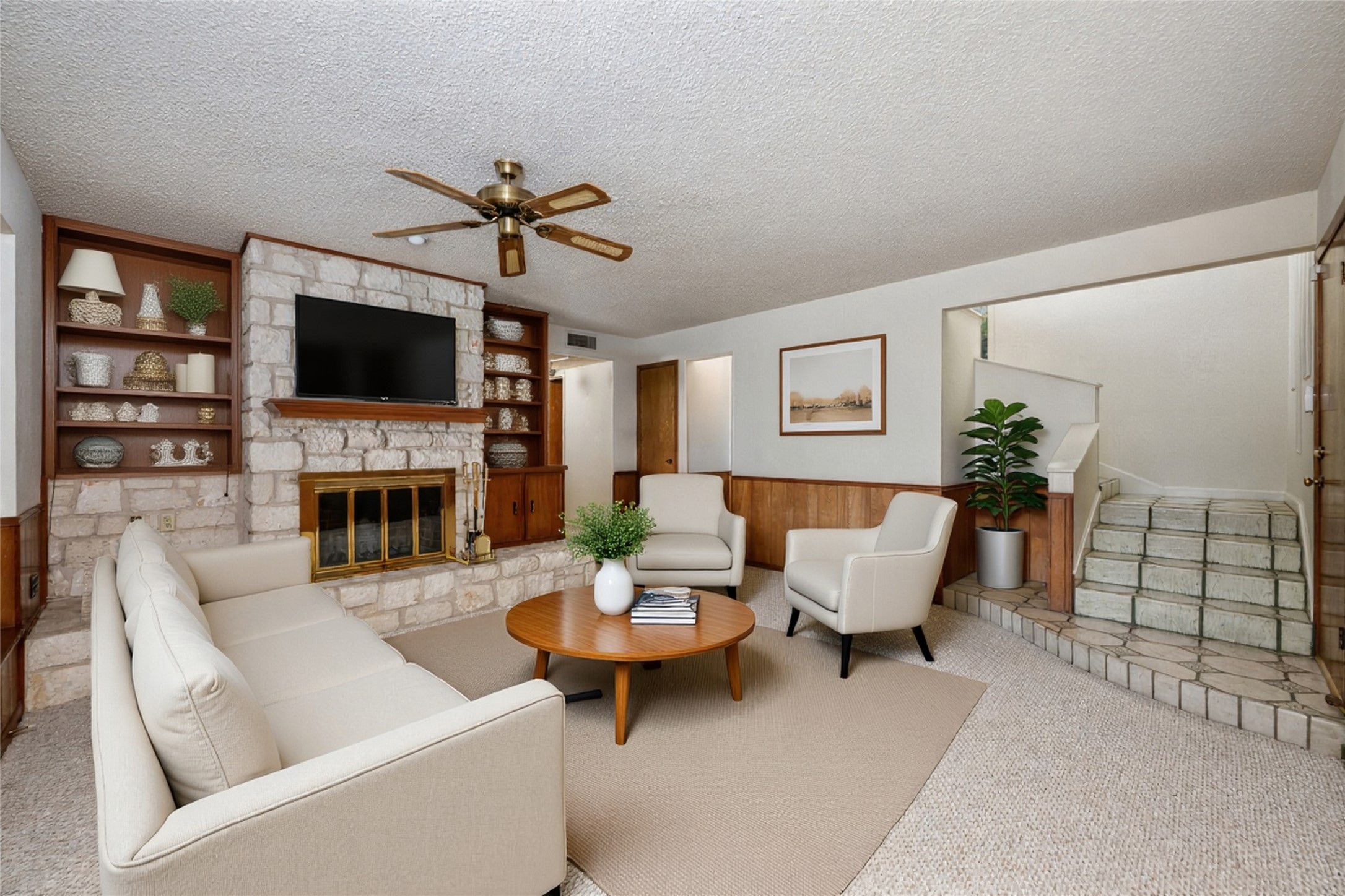 5319 Musket Ridge Austin, TX 78759 - Photo 26 of 39 A welcoming living area features a stone fireplace, built-in shelving, and direct access to a staircase.