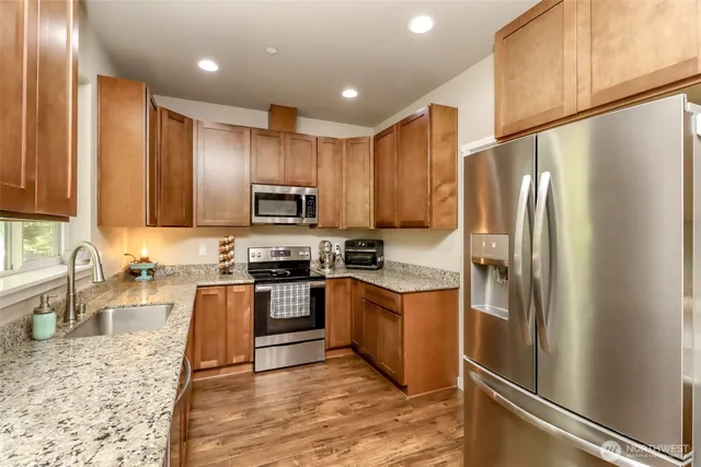 a kitchen with granite countertop stainless steel appliances and wooden cabinets