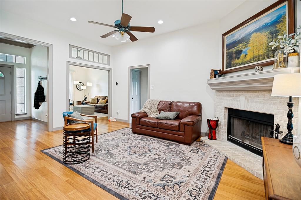 5643 West Caylor Road Fort Worth, TX 76244 - Photo 5 of 37 Spacious living area featuring wood-finish flooring, a white brick fireplace with a substantial mantel, a recessed ceiling, and a ceiling fan
