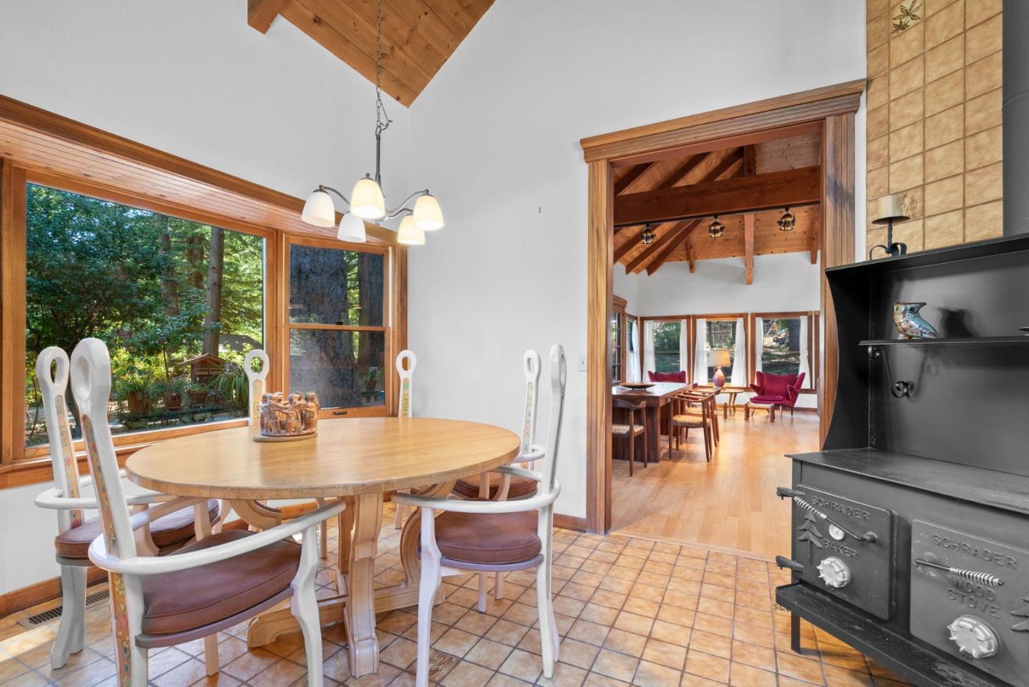 4611 Bonny Doon Road Santa Cruz, CA 95060 - Photo 57 of 94 a dining room with wooden floor a chandelier a glass table and chairs